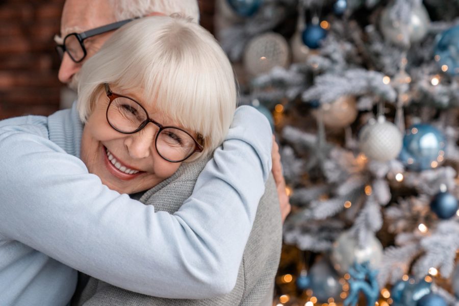 Senior couple hugging at home at Christmas time