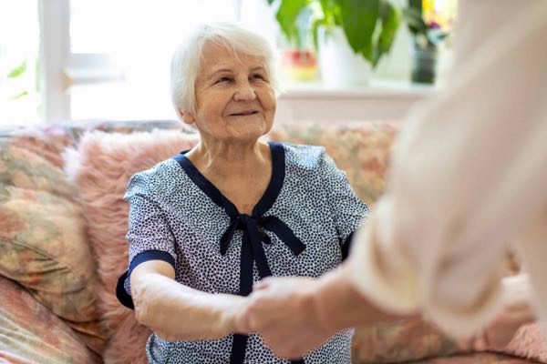 Female caregiver helping elderly woman with Alzheimer's